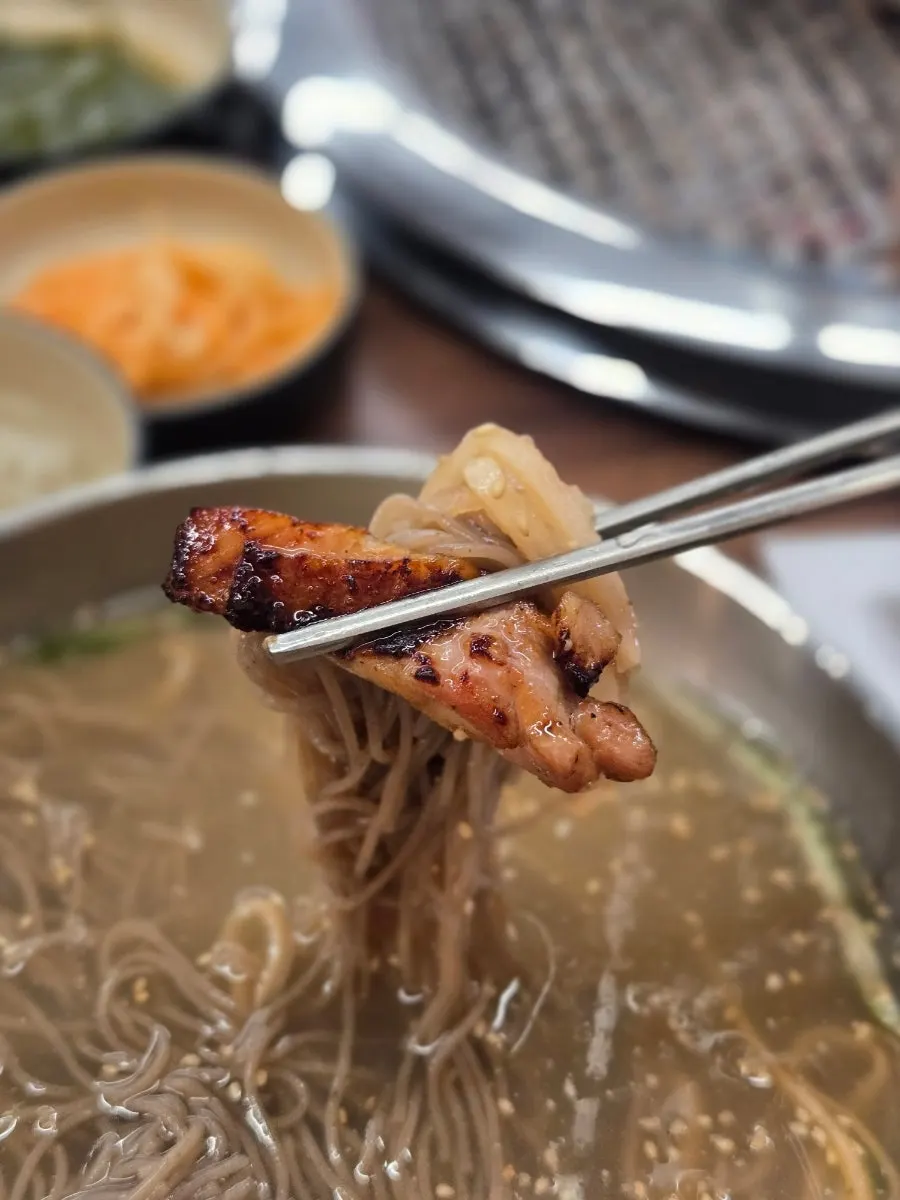 Charcoal soy sauce dakgalbi laid over jatmul makguksu noodles