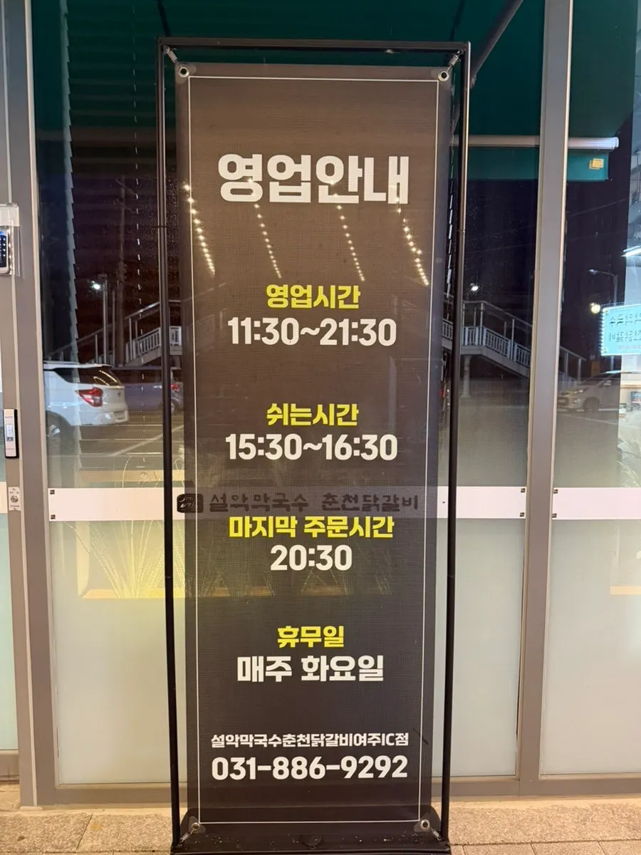 Storefront sign with business hours posted at the entrance