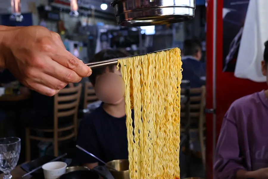 Noodles lifted up to cool while cooking the ramyeon