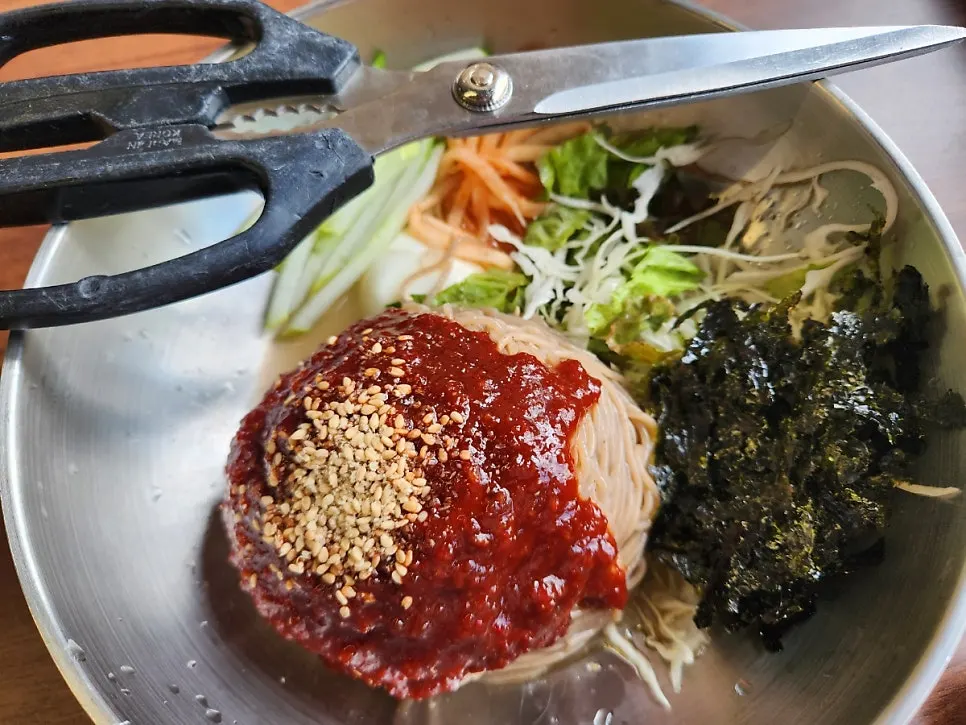 Dakgalbi and rice cake sticks together on the grill plate