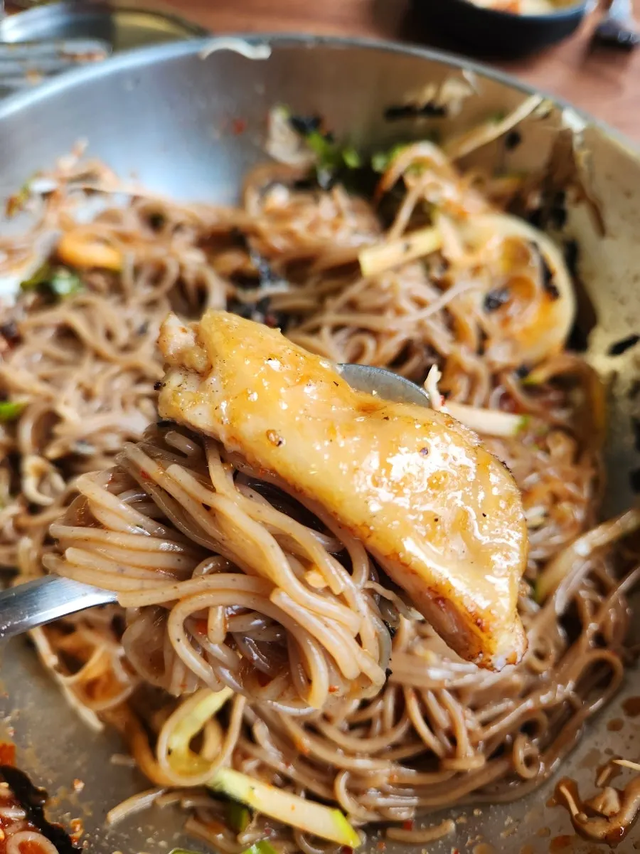 Bibim makguksu topped with sesame and seaweed flakes