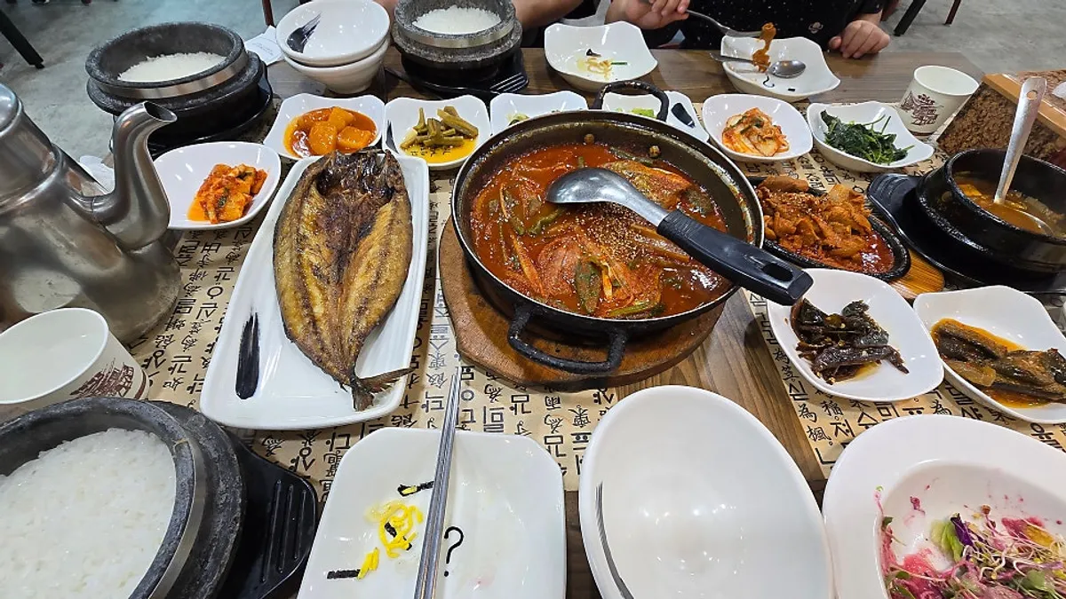 Full table spread of braised cutlassfish, stone-pot rice, and side dishes