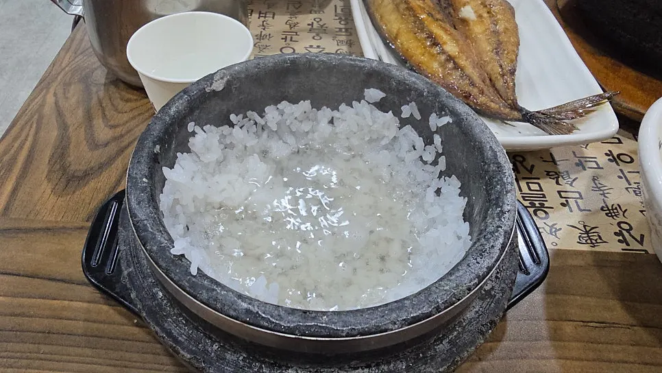 A bowl of stone-pot rice topped with side dishes
