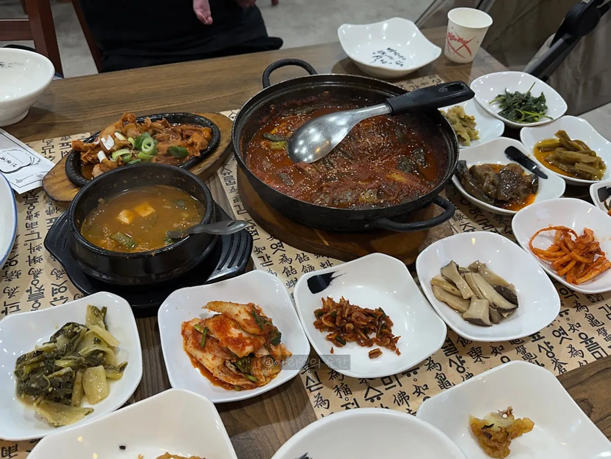 Table with namul side dishes and pork stir-fry