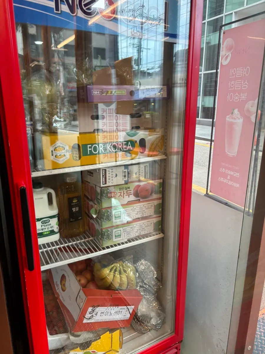 Bananas, plums, and other fresh fruit inside the store fridge