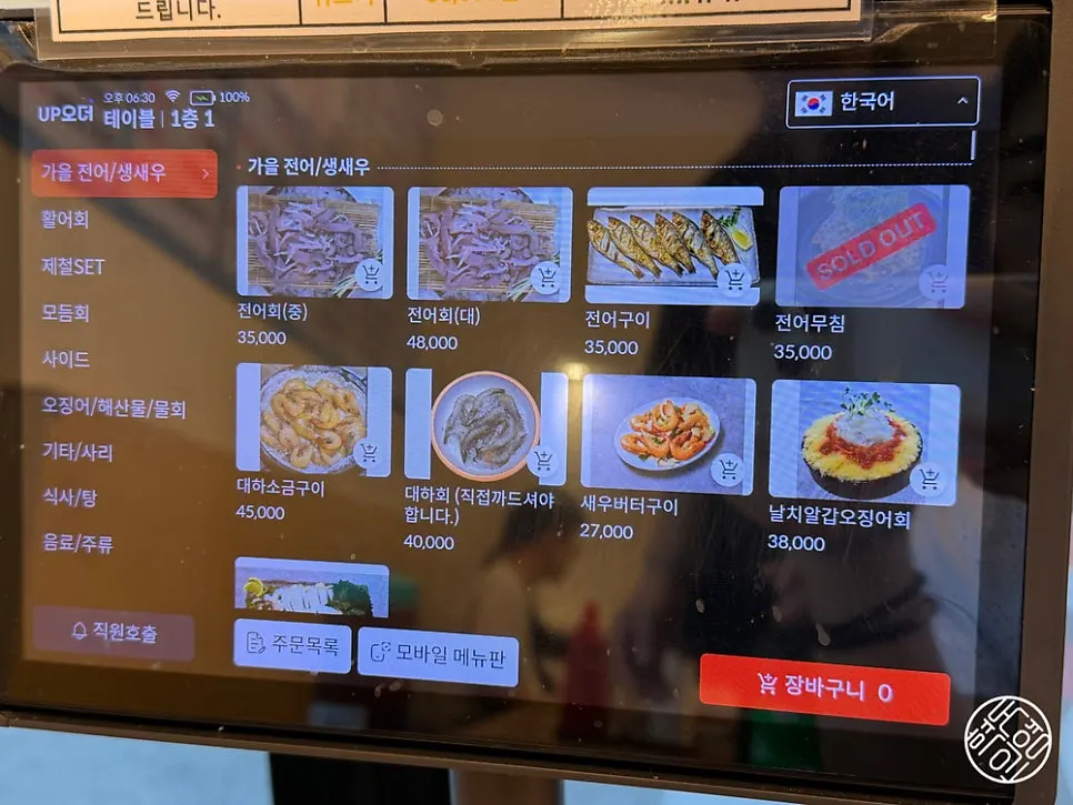 Menu board listing sashimi, seafood, and grilled dishes