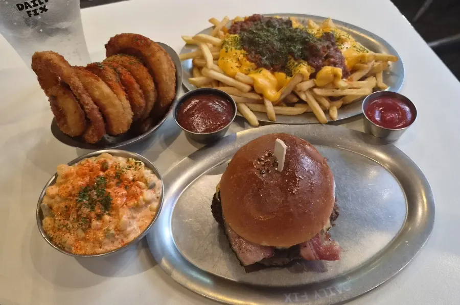 Bacon cheeseburger and side dishes spread