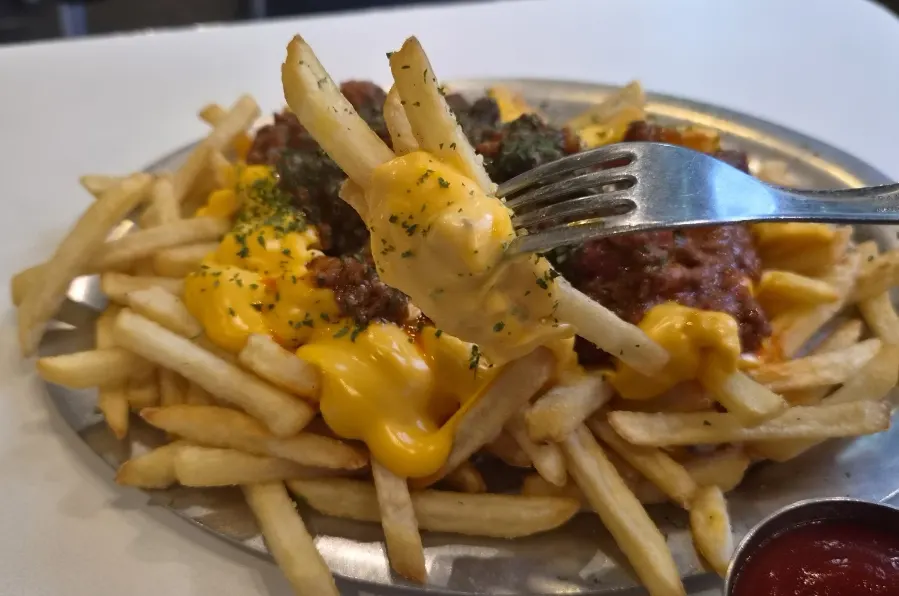 Fries topped with chili sauce and cheese