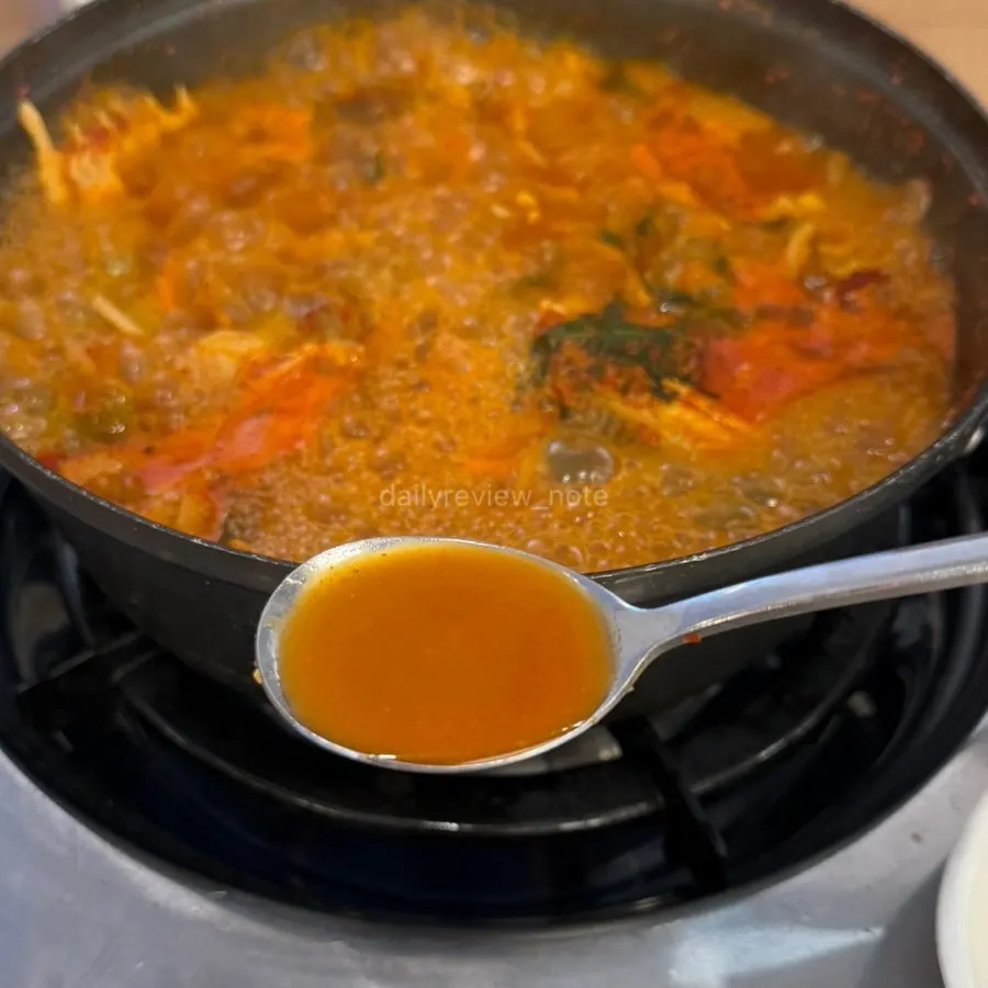 Pot of seodeori spicy fish stew topped with crown daisy greens
