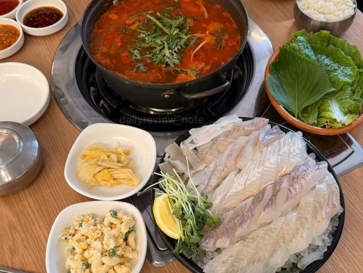 A spoonful of rice topped with stew broth and radish
