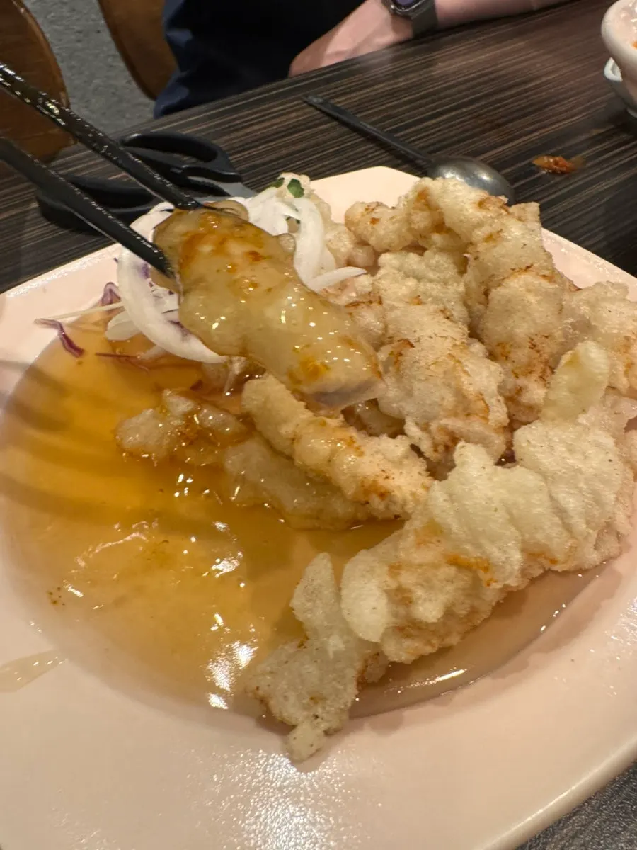 A piece of sweet and sour pork coated in tangy sauce