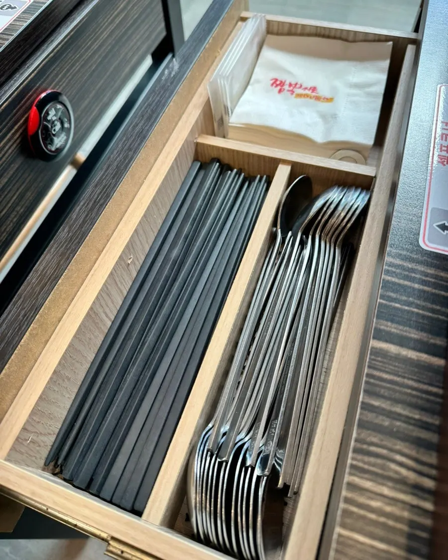 Table drawer with neatly organized chopsticks and napkins