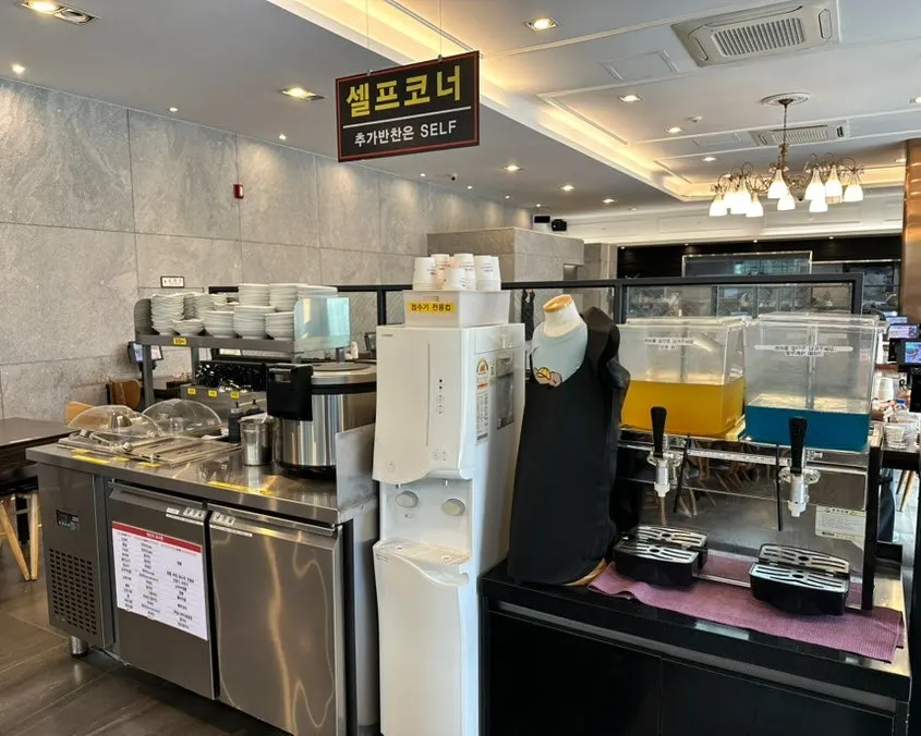 Self-serve bar at Jjamppong Jijon Yeoksam Branch stocked with side dishes and rice