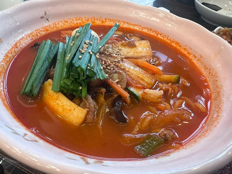 Table set with jjamppong, menbosha, and sticky-rice sweet and sour pork