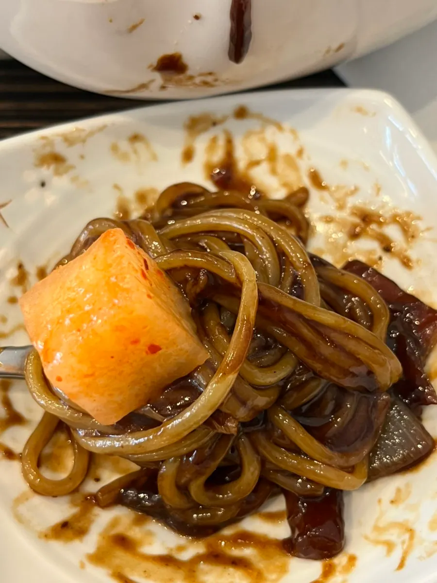 Jjajangmyeon and jjamppong sitting side by side in the jjamjjamyeon bowl