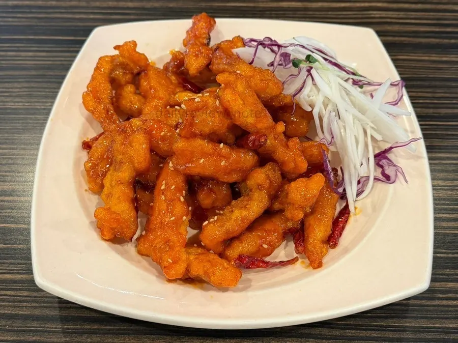 Small Sichuan sweet and sour pork coated in red sauce