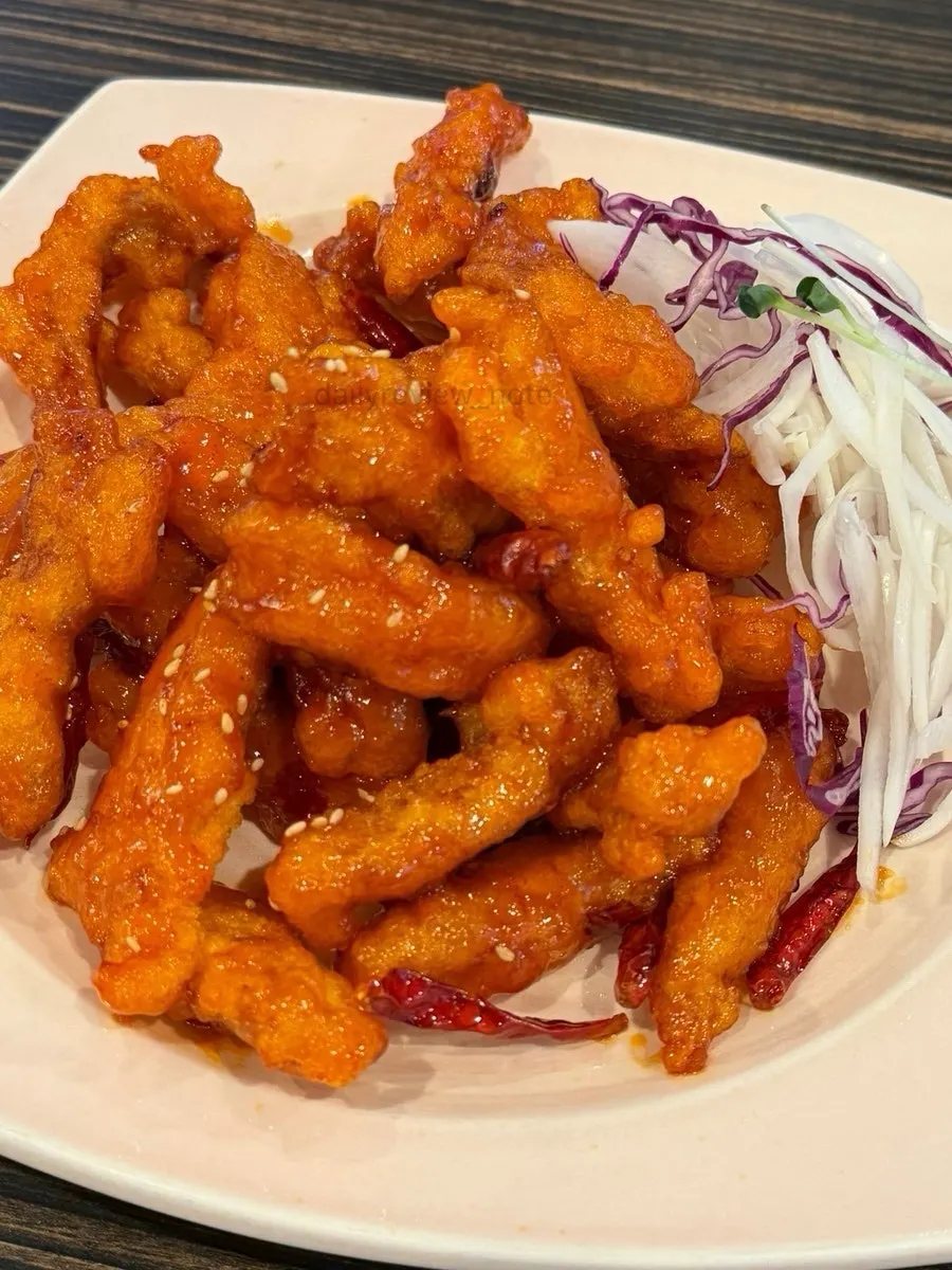 Close-up of Sichuan sweet and sour pork with dried chili peppers