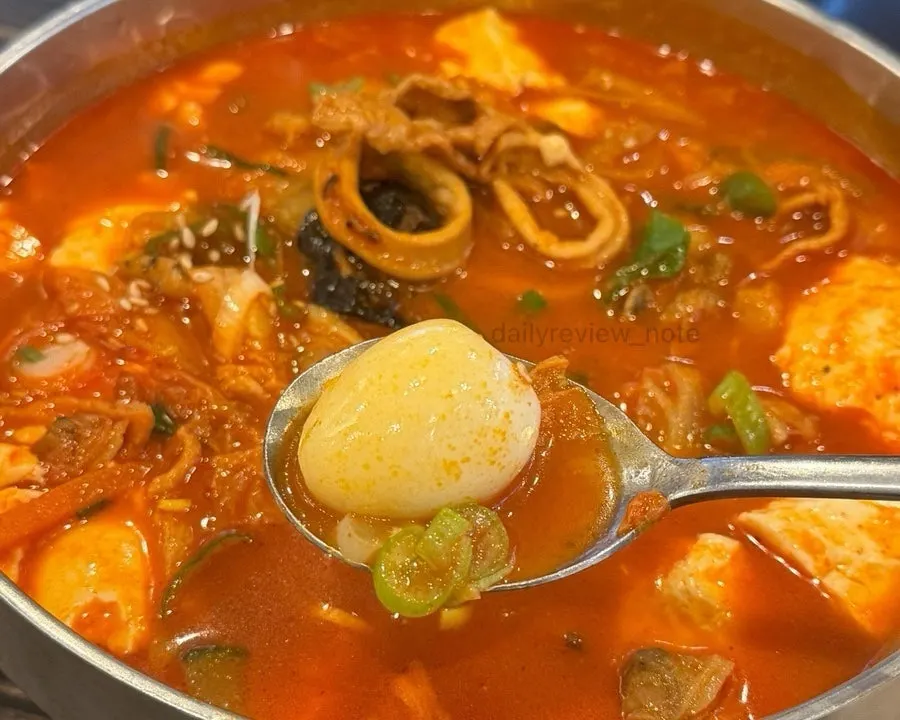 Jjamppong broth showing soft tofu and squid ingredients