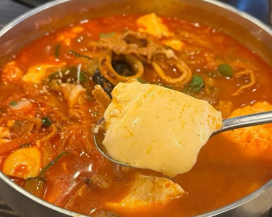 A large chunk of soft tofu scooped up with a spoon