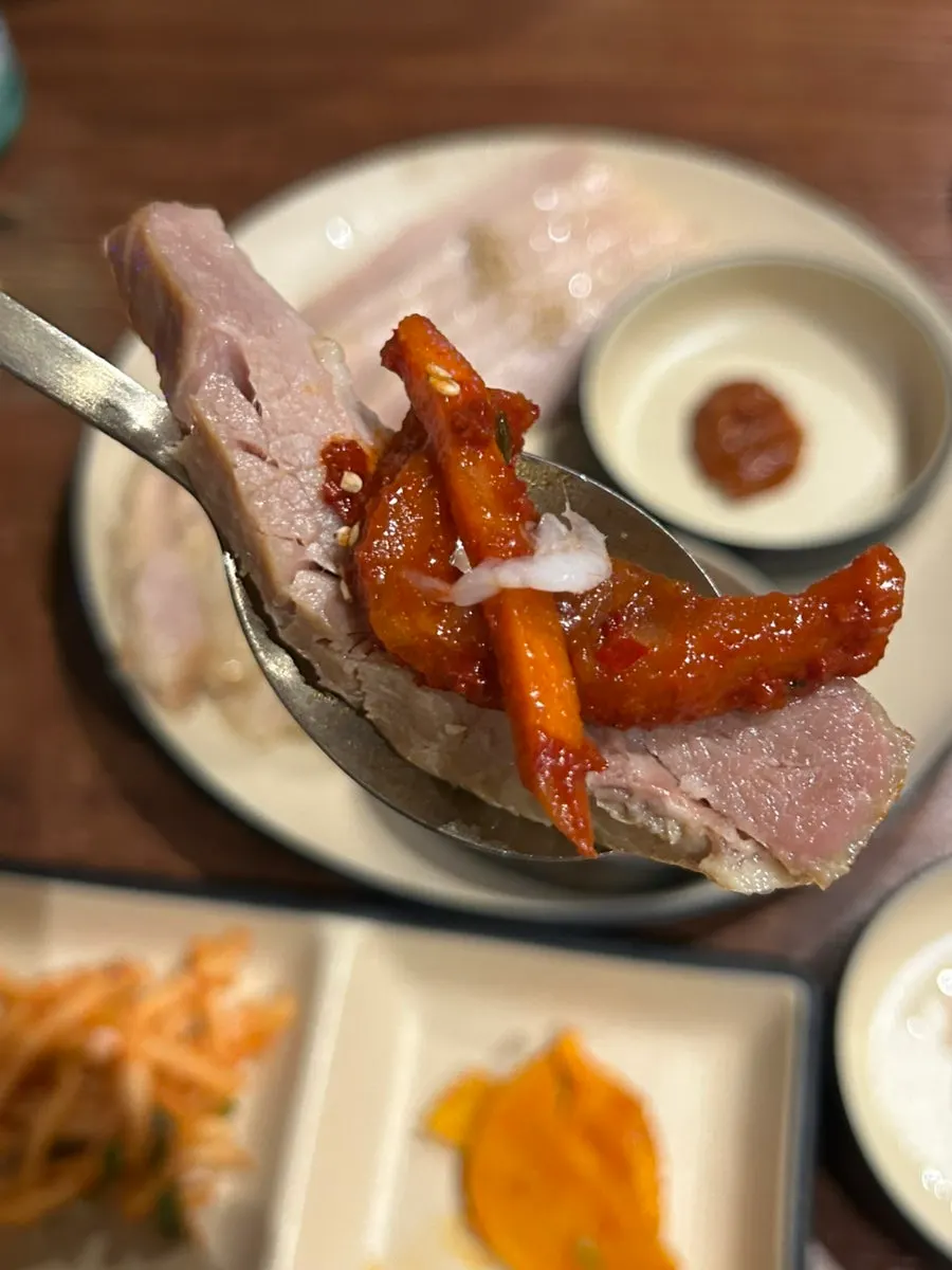 A piece of suyuk topped with bossam radish kimchi