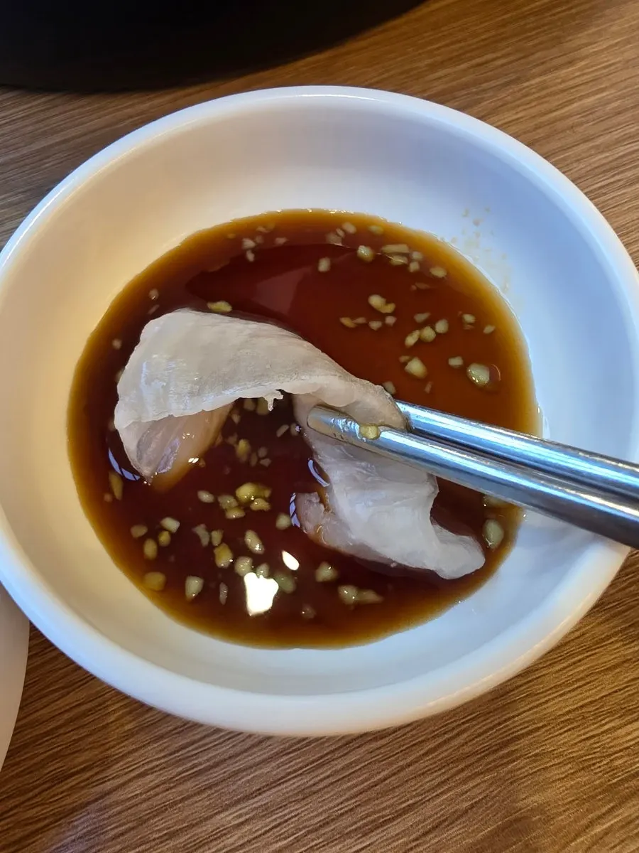 Halibut sashimi dipped in wasabi soy sauce