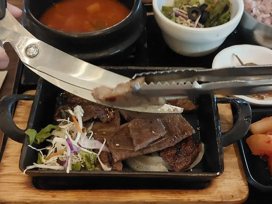 Charcoal LA galbi and side dishes on a hot iron pan