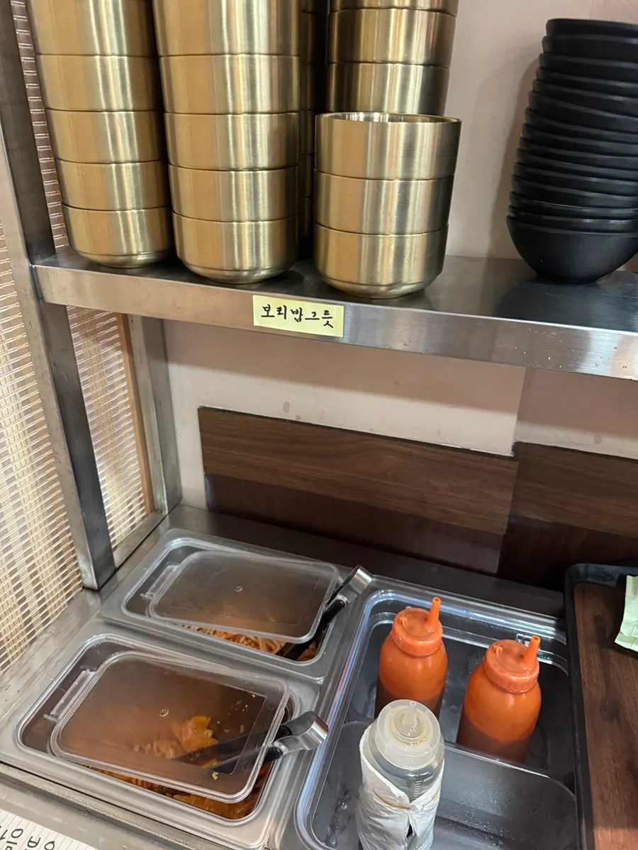 Rice cooker at the self-serve bar with radish salad, gochujang sauce, and sesame oil