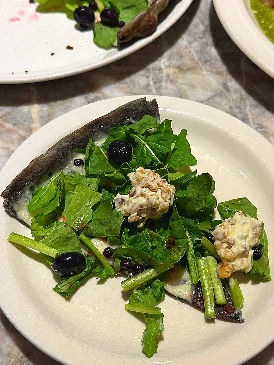 Pizza topped with blueberries and walnuts