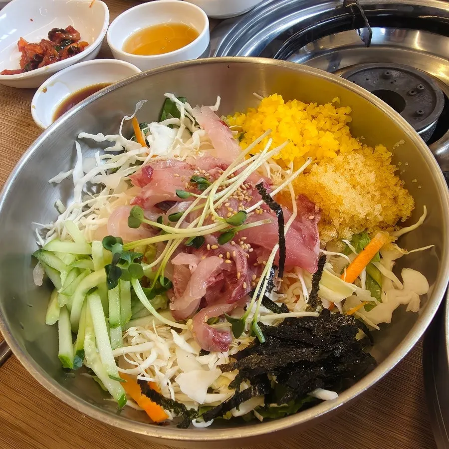 Raw fish rice bowl with shredded seaweed and vegetables