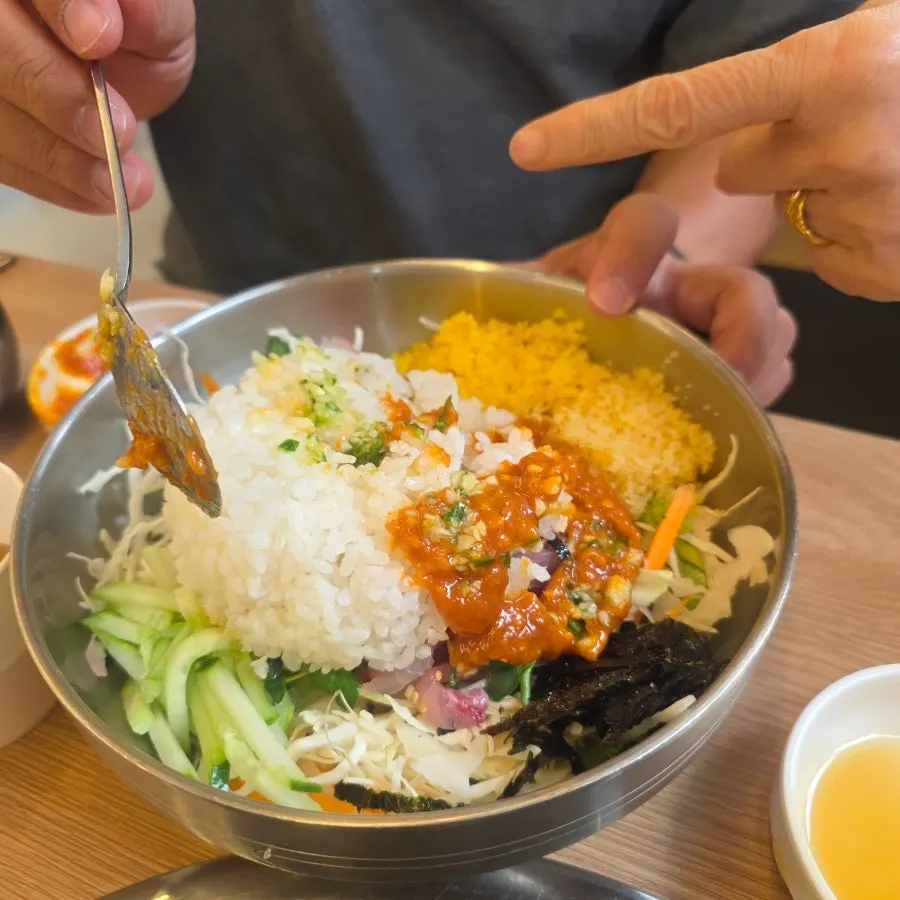 Raw fish rice bowl being mixed with rice and sauce