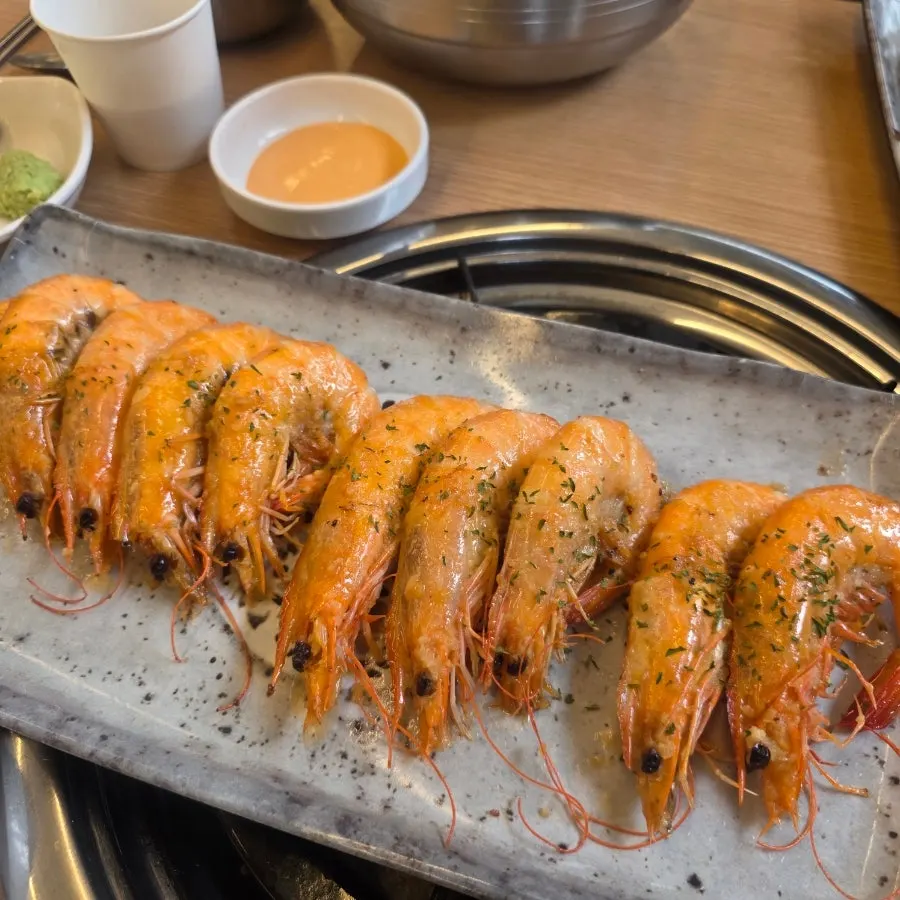 Butter-grilled shrimp lined up on one plate