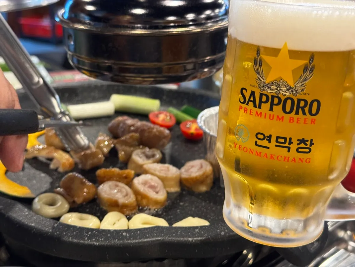 Makchang grilling alongside a Sapporo draft beer