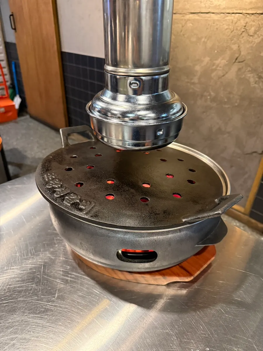 Cast-iron grill over charcoal with the meal laid out