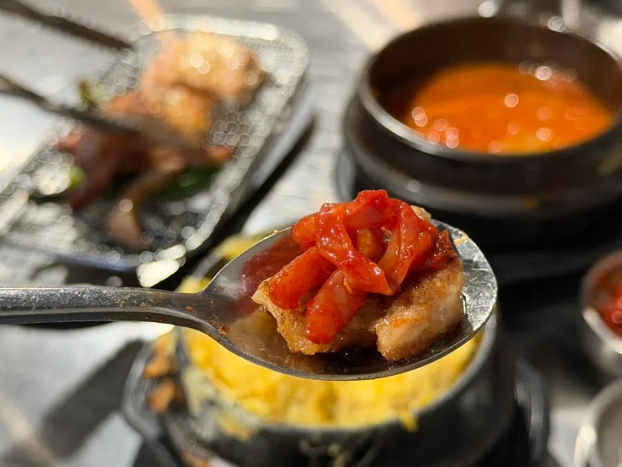 A grilled piece of fresh short rib topped with jeotgal