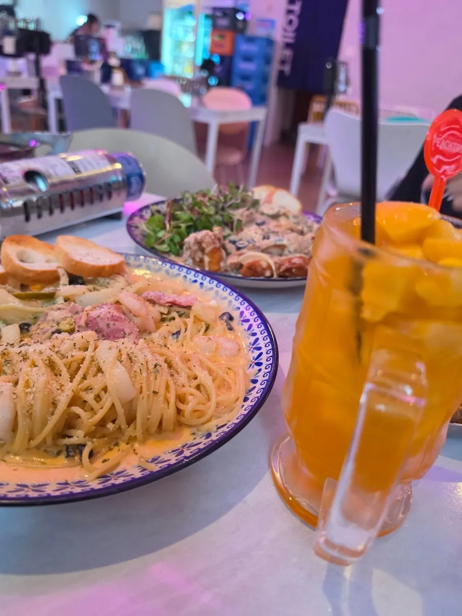 Table spread with chicken, pasta and jjamppong together