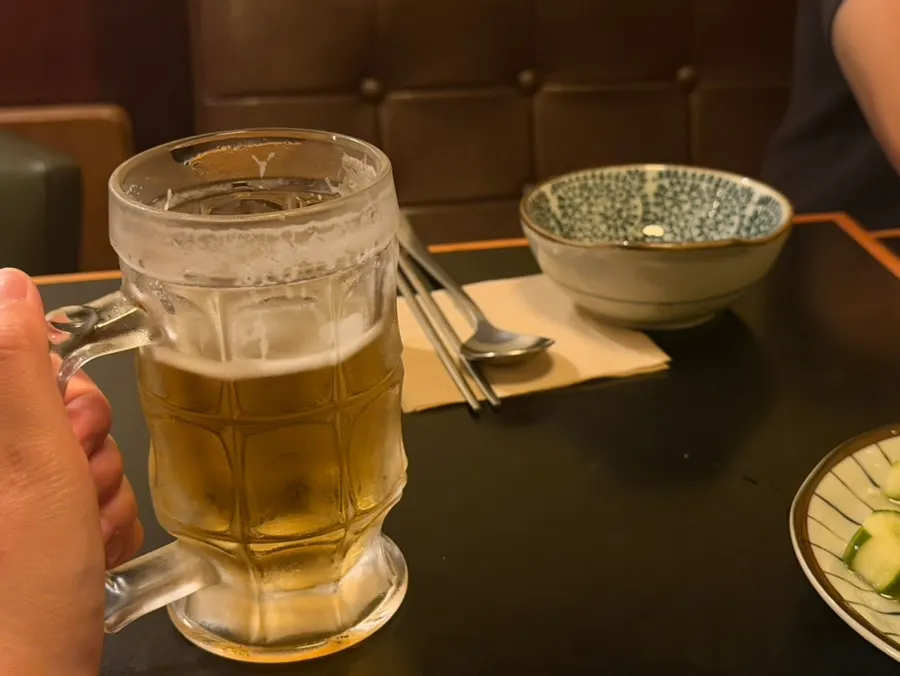 Half-finished glass of 330ml Asahi draft beer
