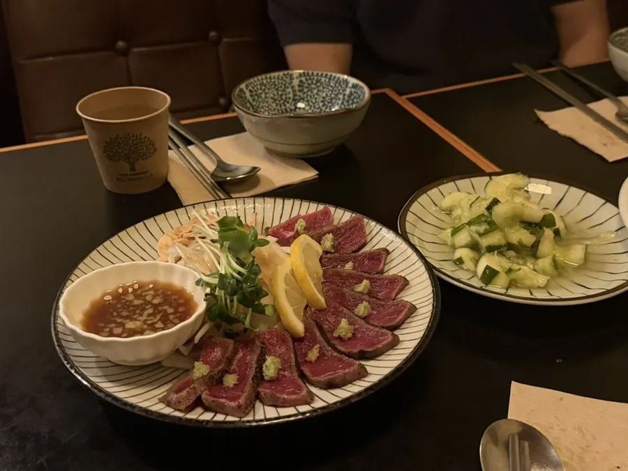 A plate of beef tataki topped with wasabi