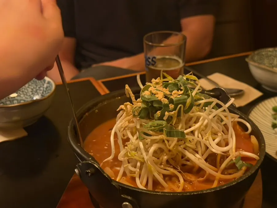 A pot of beef brisket nabe loaded with bean sprouts