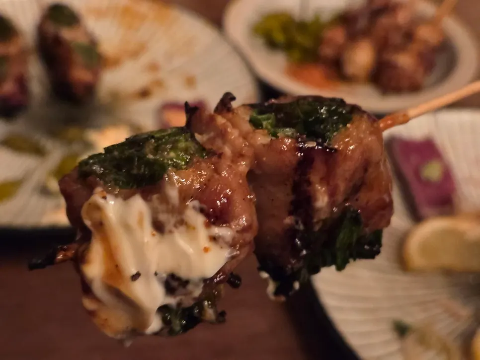 Pork belly scallion skewer served alongside beef tataki