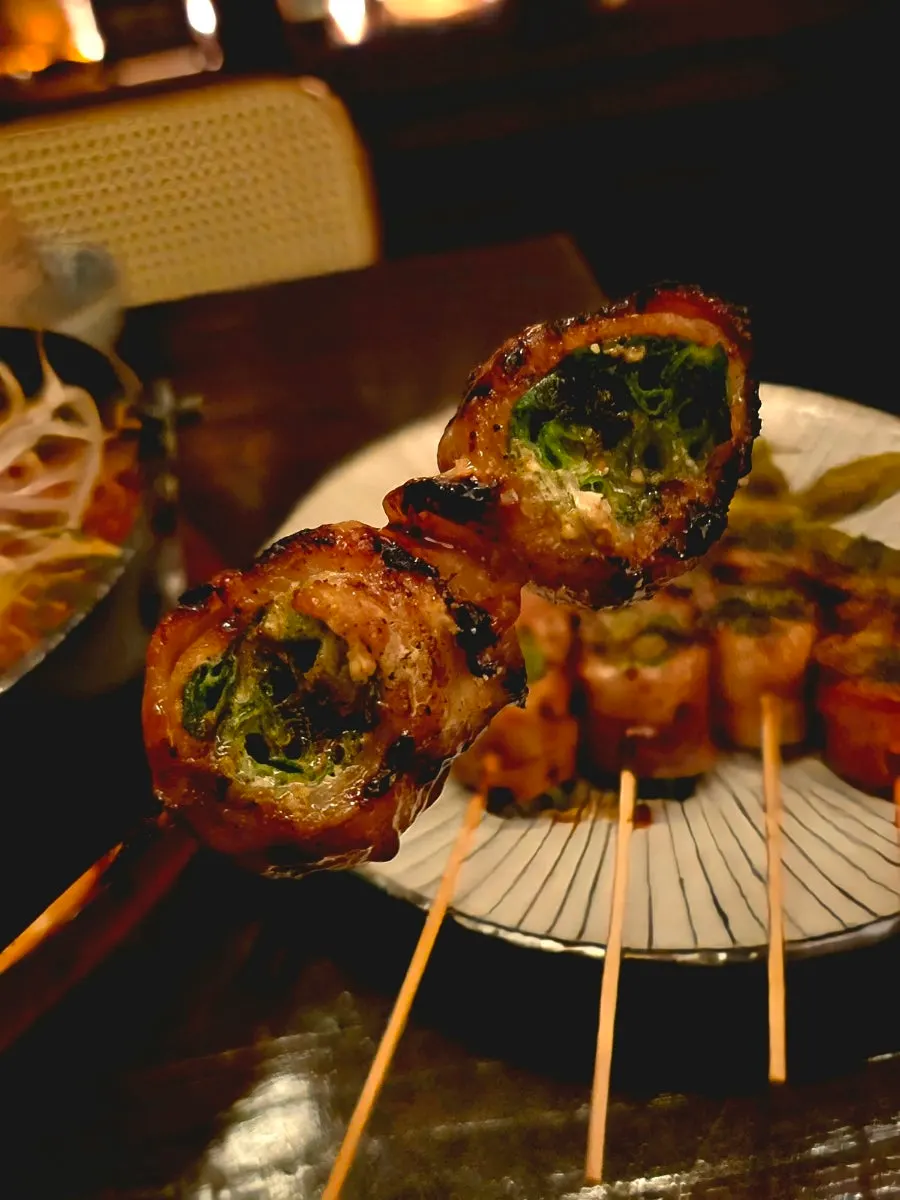 Pork belly-scallion skewers served with pickled chili and sauce