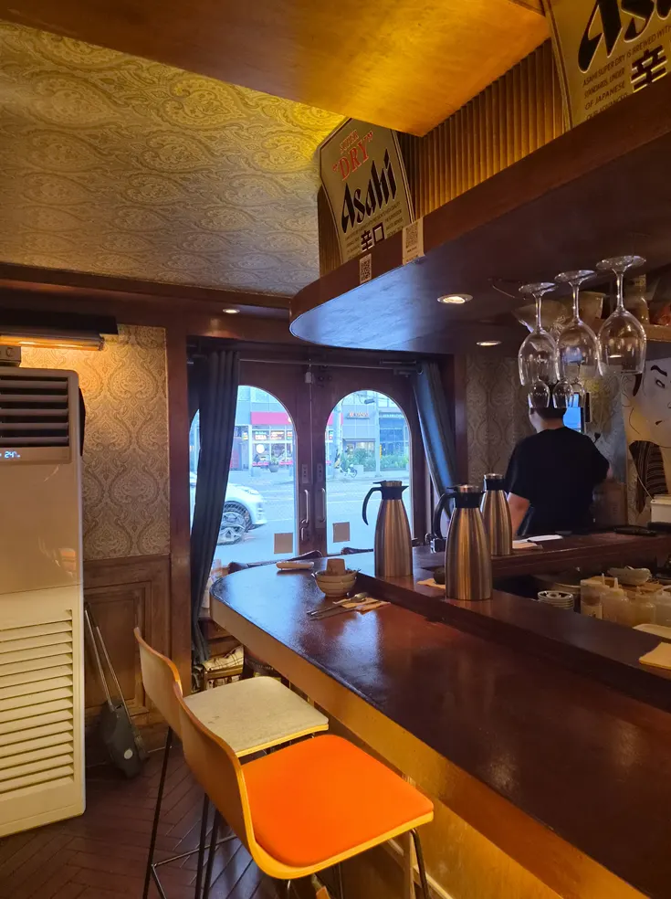 Bar-style seating and open kitchen near the entrance