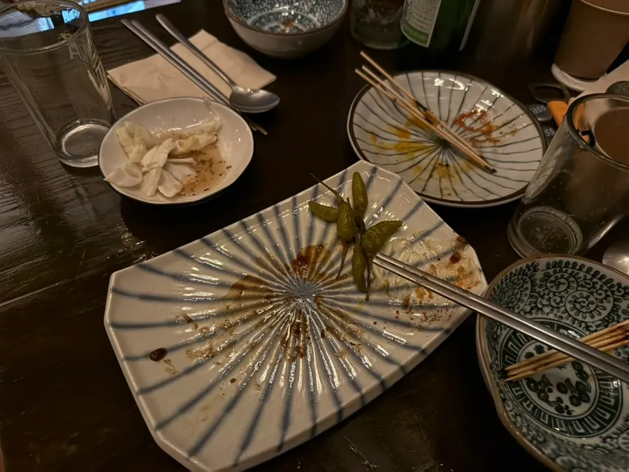 비운 꼬치 접시와 술잔이 놓인 테이블