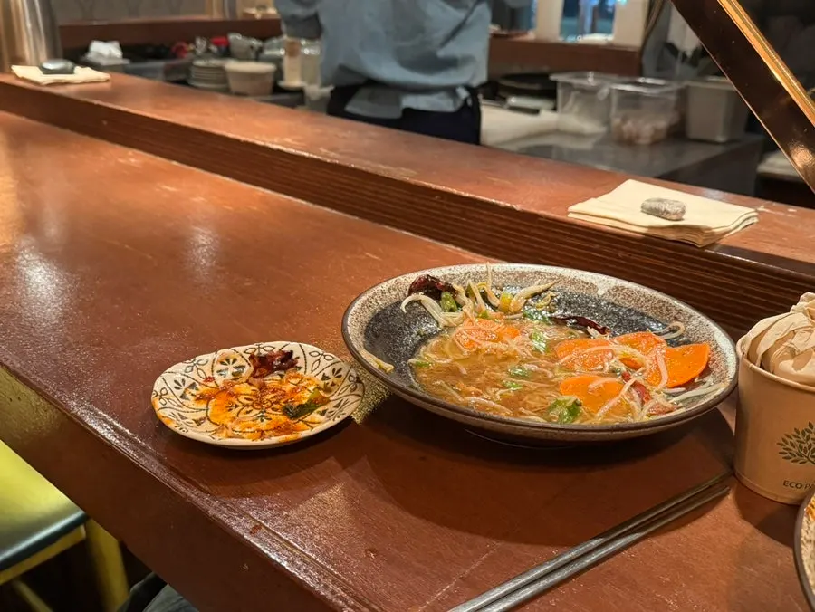 A bite of spicy seafood yaki udon with juicy broth