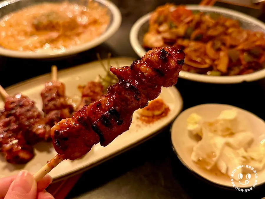 닭꼬치 한 점을 집어든 모습