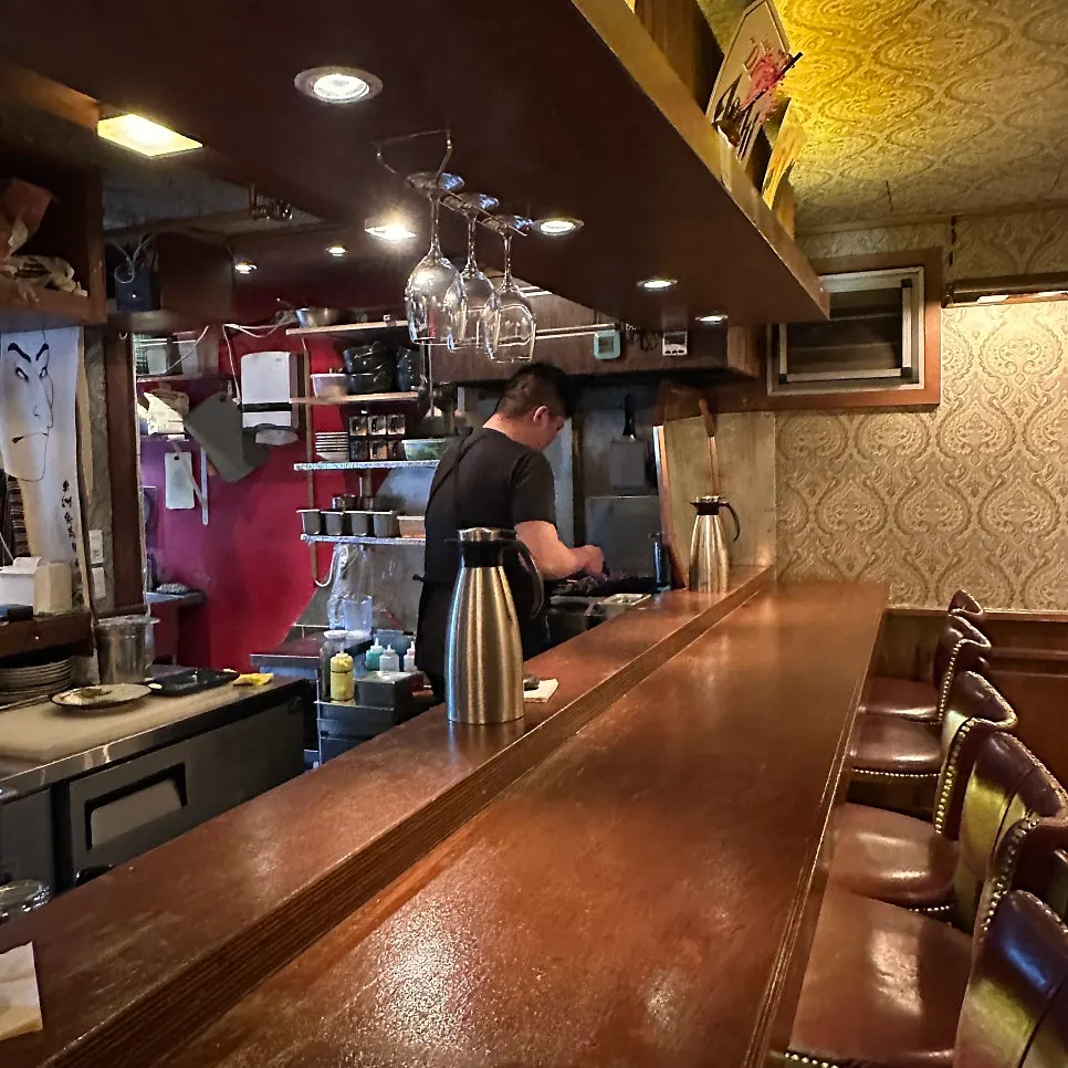 Skewers being grilled in front of the bar counter