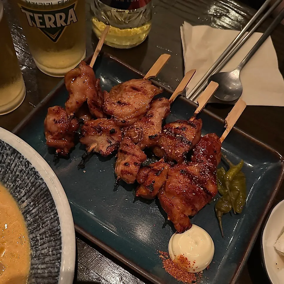 Chicken skewers and pork belly-scallion skewers on the table