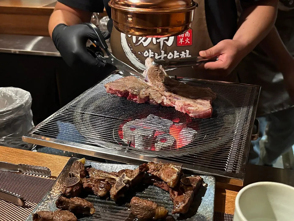 Second round of lamb ribs placed on the charcoal grill