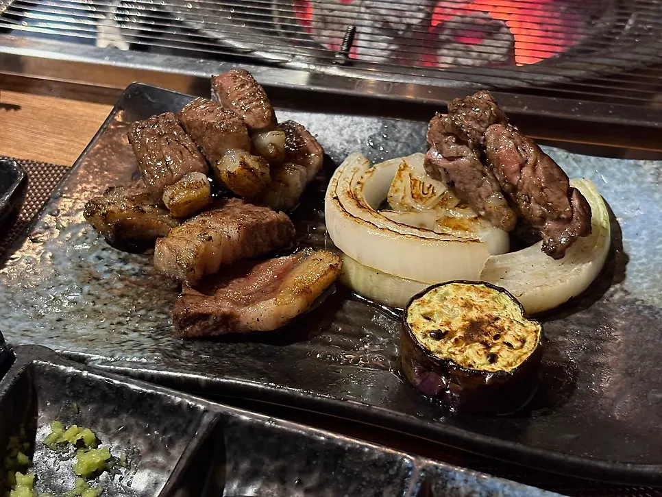 Vegetables and foil-wrapped mushrooms grilling alongside the lamb