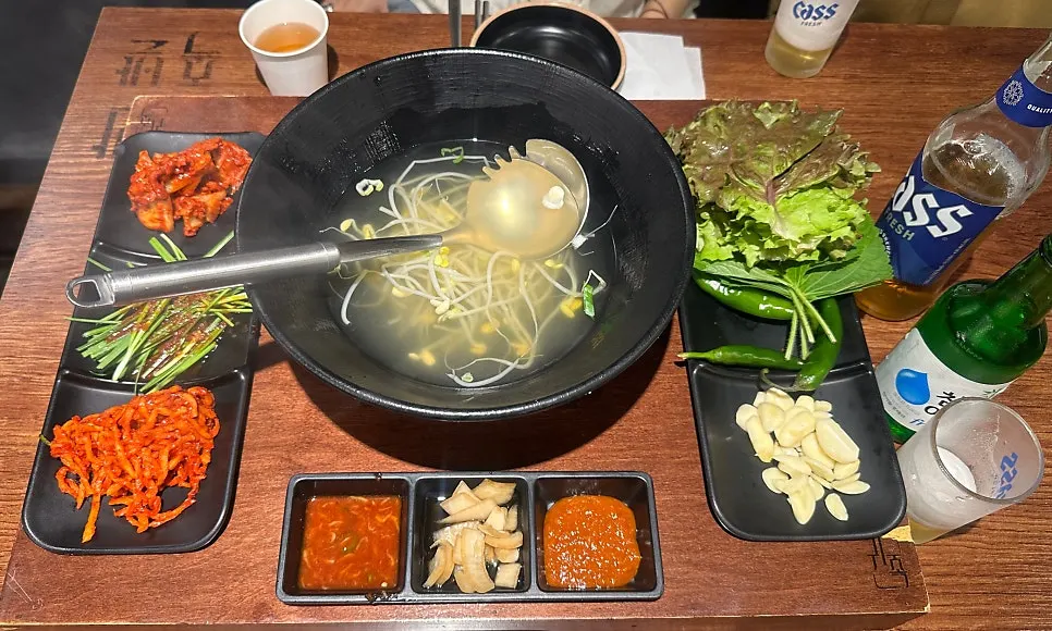 A spread of side dishes including bean sprout soup and kimchi