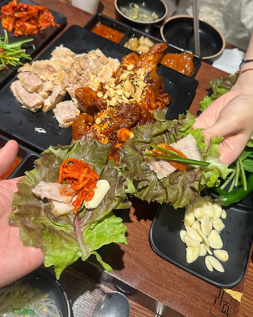 Lettuce wrap topped with jokbal and radish kimchi